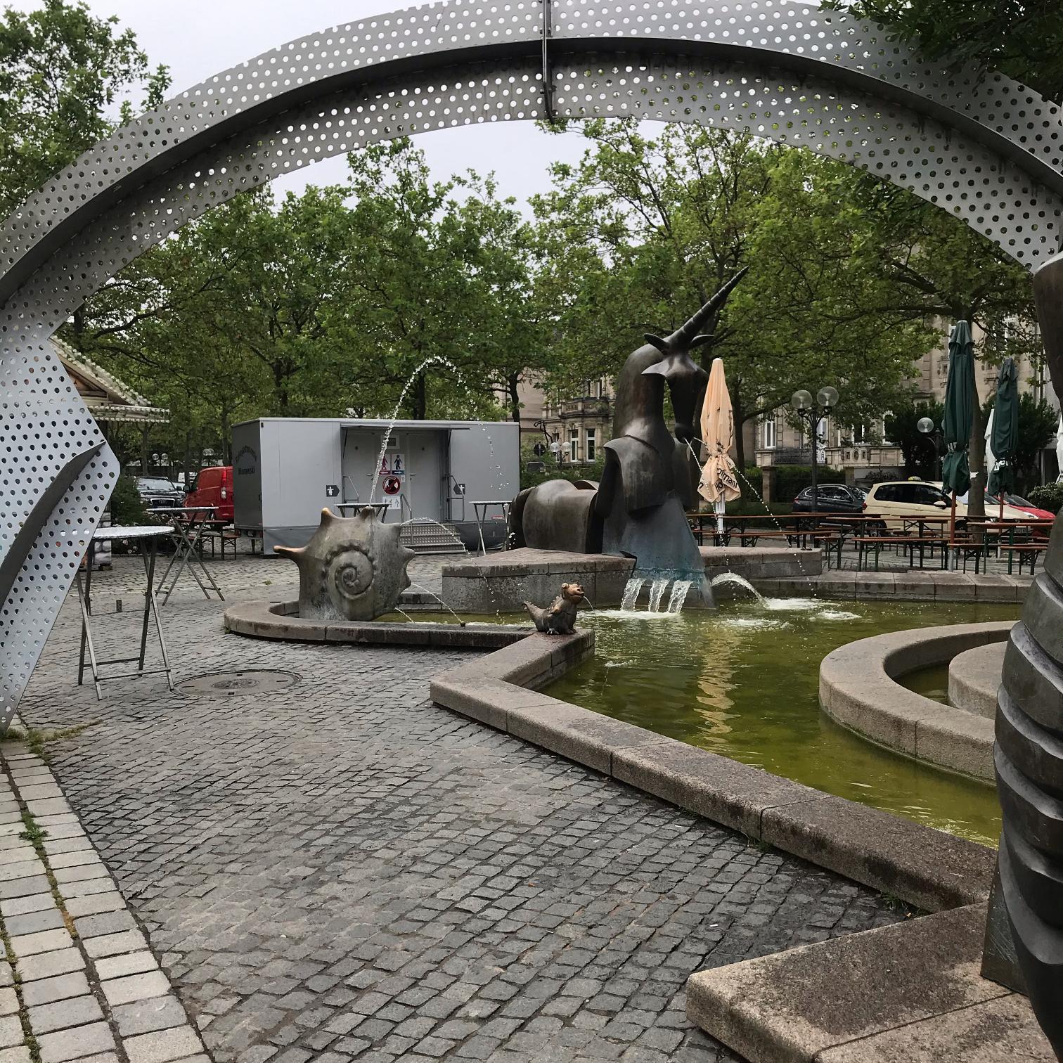 Brunnen mit Skulpturen und Bäumen